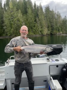 A man holding a big fish on a boat