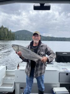 A man holding a big fish on a boat